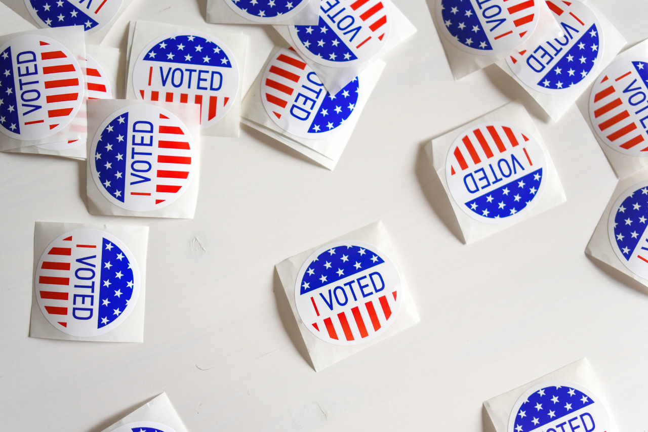 red, white, and blue I voted stickers scattered across a white background