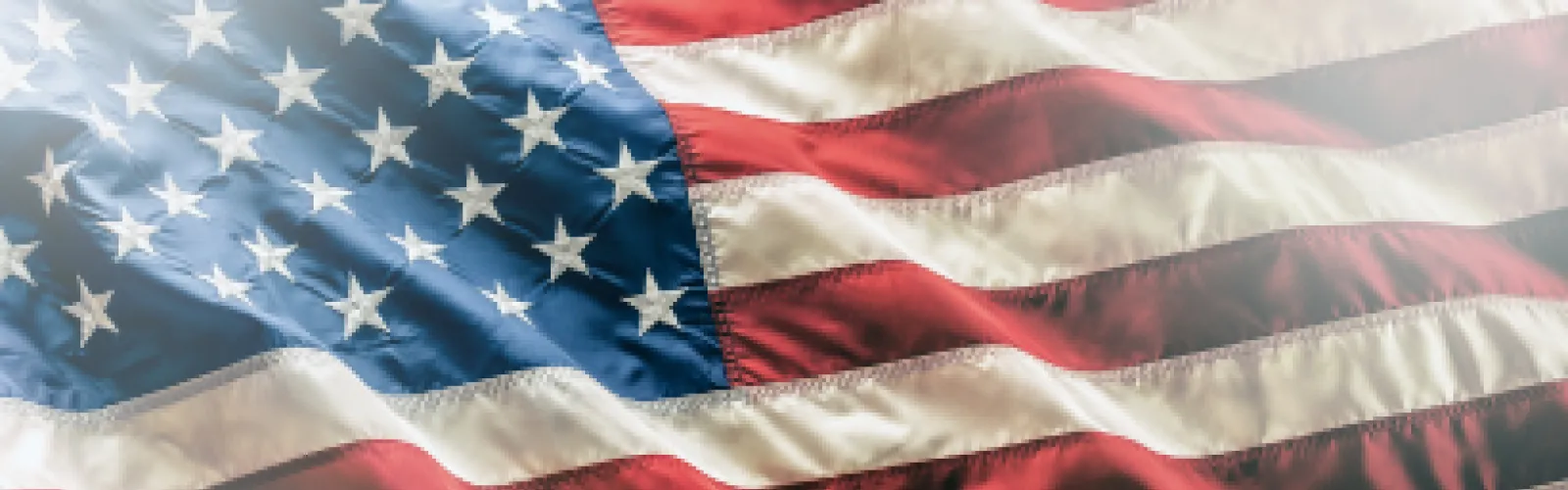 A close-up view of the United States flag, showing the stars on a blue field and red and white stripes.